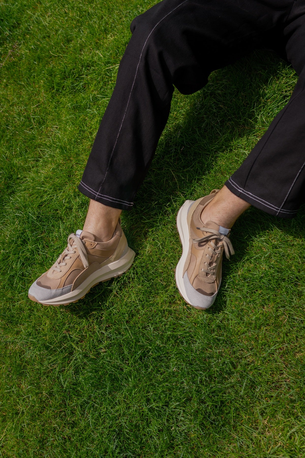 芝生の上でNOVESTA FLUX BEIGE（フルックス）を着用したスタイリング